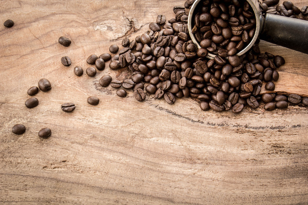 Roasted Columbian coffee beans placed on a wooden table. - Photo, image