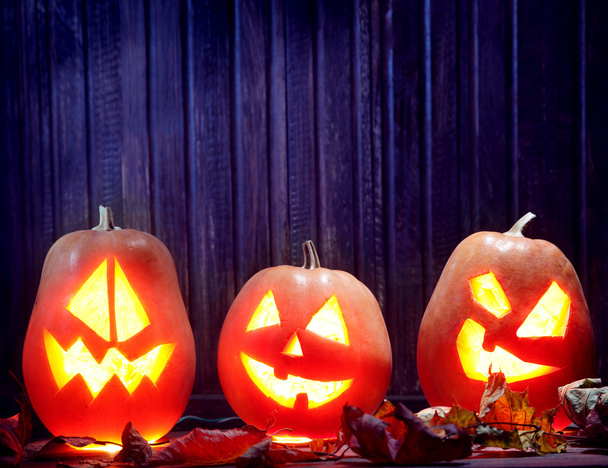 Jack o lanterns  Halloween pumpkin face on wooden background  - Photo, Image