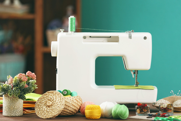 Sewing machine on table in workshop - Фото, изображение