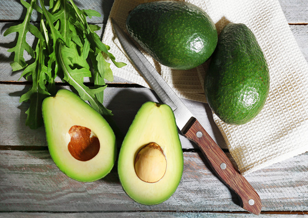 Sliced avocado, arugula on wooden background - Foto, Imagem