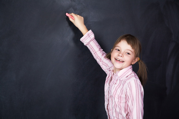 schoolchild on blackboard background - Fotó, kép