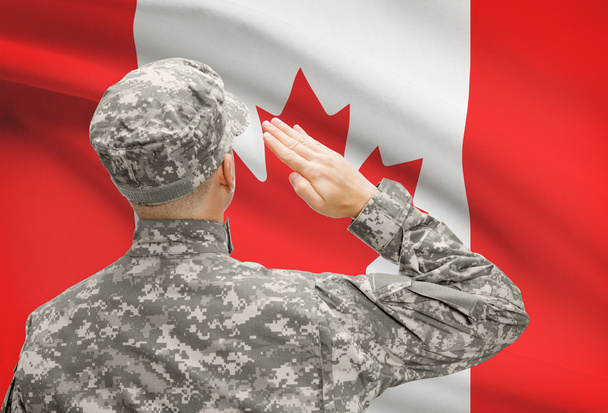 Στρατιώτης στο καπέλο που αντιμετωπίζει η εθνική σημαία σειρά - Καναδά - Φωτογραφία, εικόνα