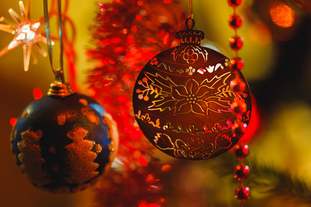 Złota ozdoba w Boże Narodzenie drzewo otoczone kolorowymi światłami  - Zdjęcie, obraz