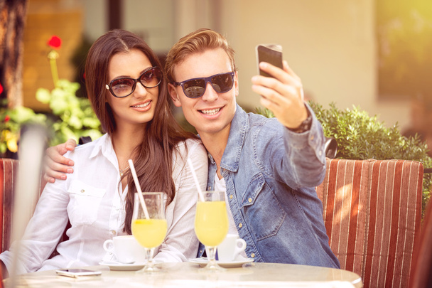 happy couple taking selfie in a cafe - Foto, imagen