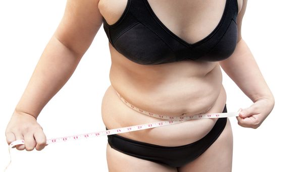 Женщина показывает жир в черном нижнем белье бюстгальтер на белой изолированной
 - Фото, изображение