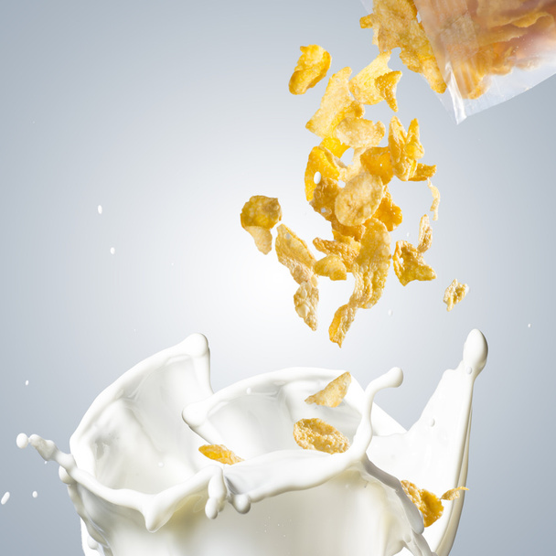Copos de maíz cayendo en la salpicadura de leche
 - Foto, Imagen