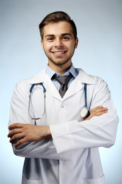 Male doctor with stethoscope on blue background - Foto, imagen