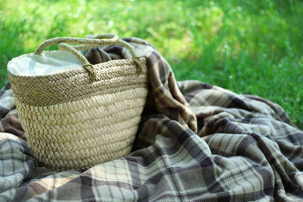 Wicker basket and Plaid for picnic on green grass - Фото, зображення