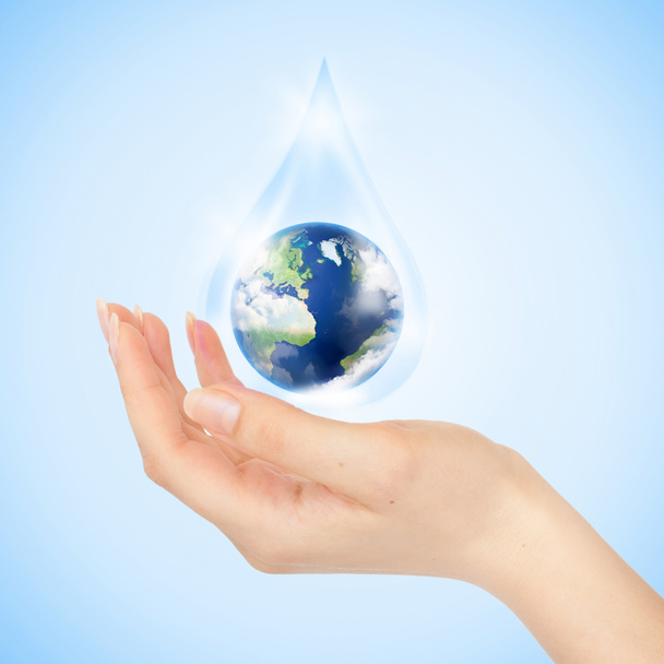 Gota de agua con la Tierra adentro y la mano
 - Foto, imagen