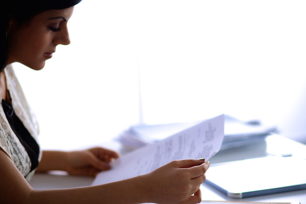 Woman with documents sitting on the desk - Zdjęcie, obraz