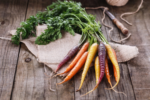 Colored carrots over rustic wooden background - Photo, Image
