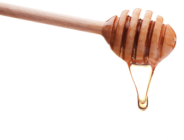 Honey dripping from wooden honey dipper - Fotografie, Obrázek