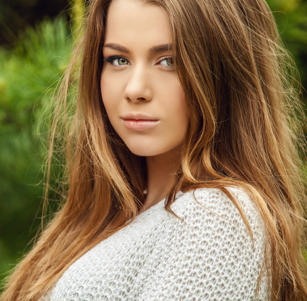 Outdoors portrait of beautiful young girl in casual white sweater. - Фото, зображення