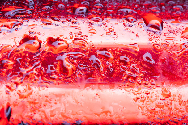 Vesipisarat punaisella metallipinnalla
 - Valokuva, kuva