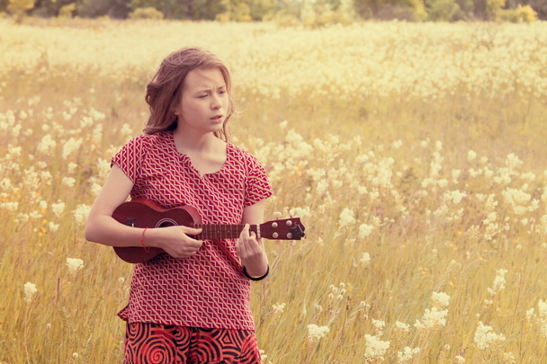 Girl on meadow with ukulele - Photo, Image