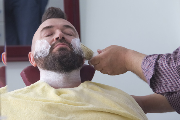 Young handsome man in beauty salon - Foto, afbeelding