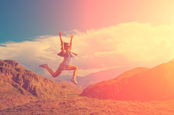 Happy girl jumping on top of rock - Fotoğraf, Görsel