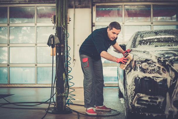 Arbeiter wäscht Luxusauto mit Schwamm - Foto, Bild