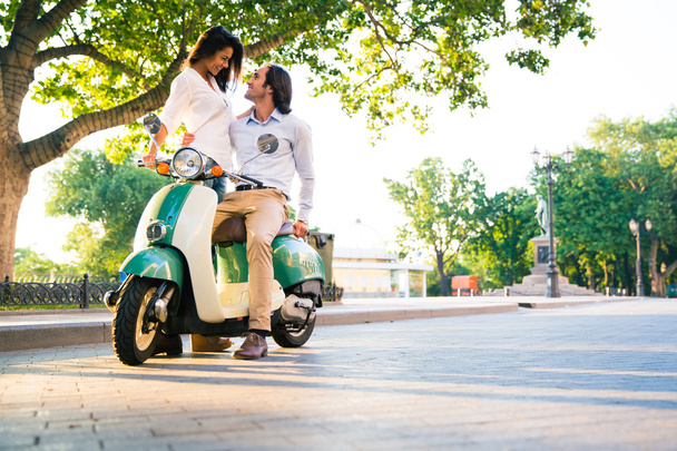 Happy beautiful couple flirting on scooter - Fotografie, Obrázek