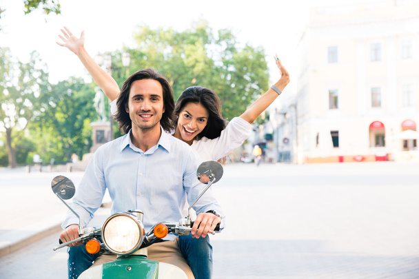 Cheerful couple riding on a scooter - Foto, Imagem