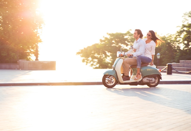 Young couple riding a scooter  - Zdjęcie, obraz