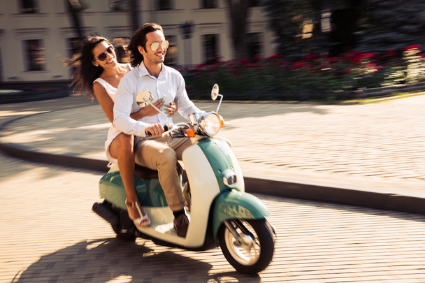 Cheerful young couple riding a scooter  - Φωτογραφία, εικόνα