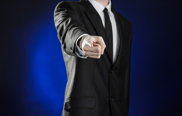 Business and the presentation of the theme: man in a black suit showing hand gestures on a dark blue background in studio isolated - Fotografie, Obrázek