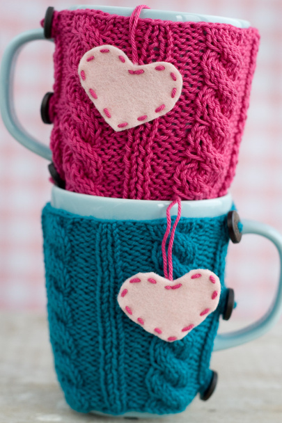 Две синие чашки в голубом и розовом свитере с войлочными сердцами
 - Фото, изображение