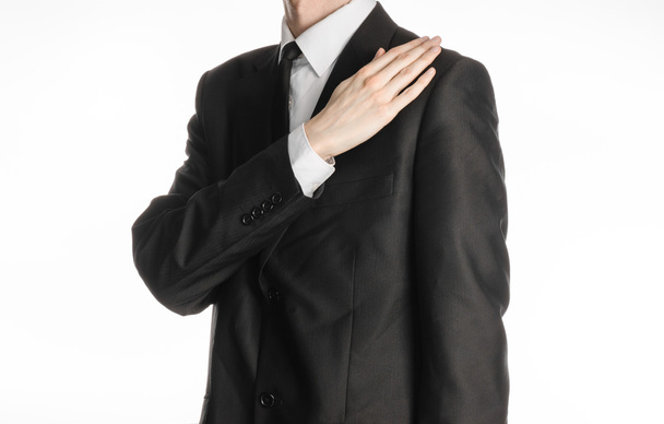 Businessman and gesture topic: a man in a black suit with a tie coat straightens his arms isolated on a white background in studio - Photo, Image