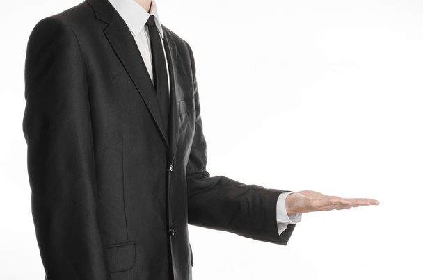 Businessman and gesture topic: a man in a black suit and tie holding his hand in front of him isolated on a white background in studio - Photo, Image