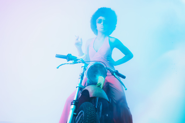 Fumar elegante mulher posando em sua motocicleta
 - Foto, Imagem