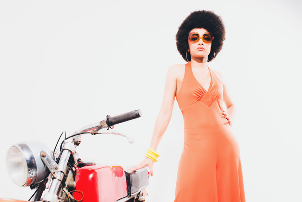 Elegante joven mujer de pie al lado de la motocicleta
 - Foto, imagen