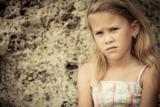 Portrait of sad blond little girl sitting on the beach - Photo, Image