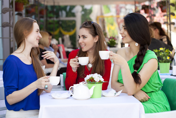 Three happy girlfriends woman sitting at a table in the summer c - Foto, imagen