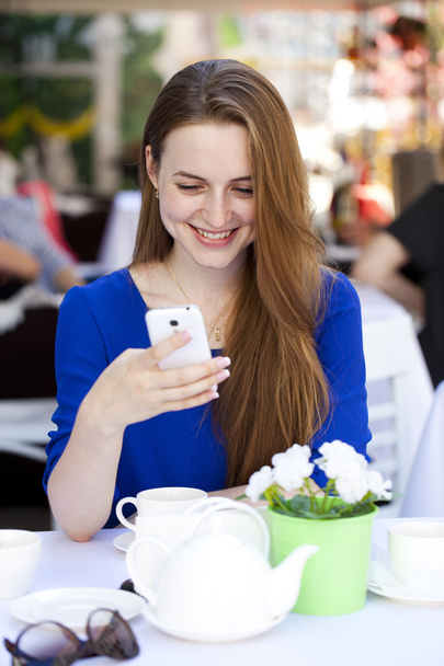 feliz bela jovem loira mulher lê uma mensagem no seu inteligente
 - Foto, Imagem