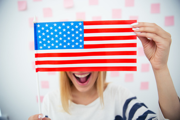 Woman covering her eyes with USA flag - 写真・画像