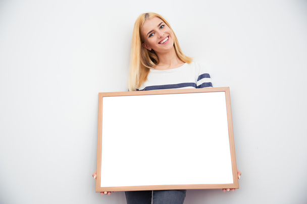 Casual businesswoman holding blank board - Fotoğraf, Görsel