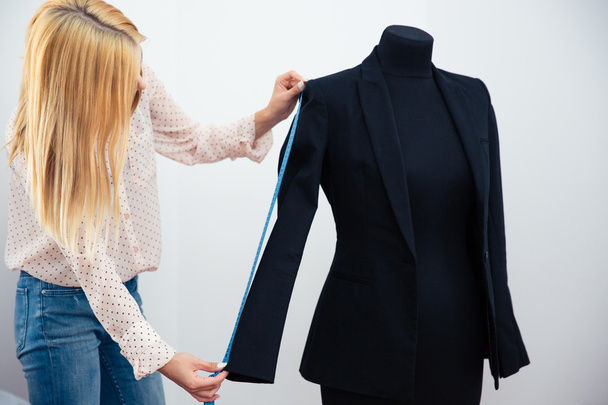 Female designer measuring jacket - Foto, afbeelding