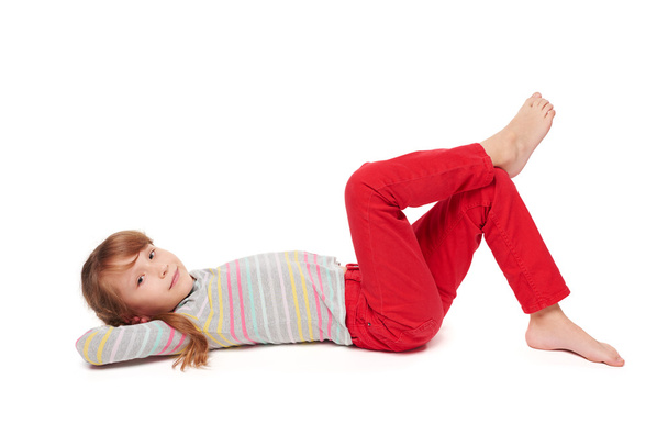 Side view of smiling child girl lying on the floor - Photo, Image