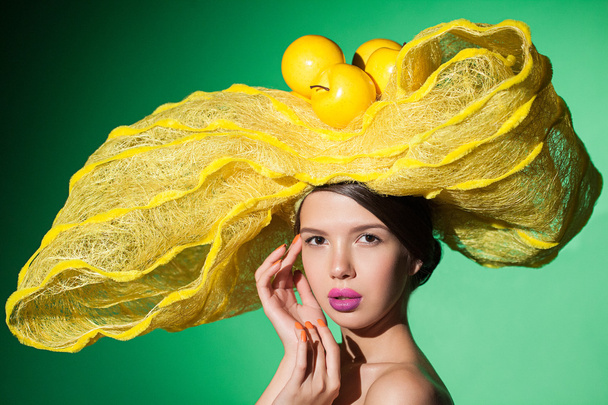 Retrato glamuroso de una jovencita guapa con sombrero amarillo creativo
. - Foto, Imagen