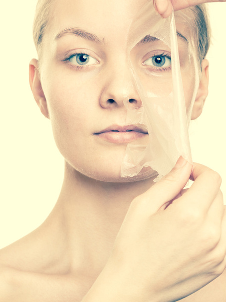 girl removing facial peel off mask - Foto, afbeelding