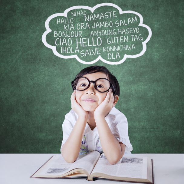 Pensive enfant étudier plusieurs langues avec manuel
 - Photo, image
