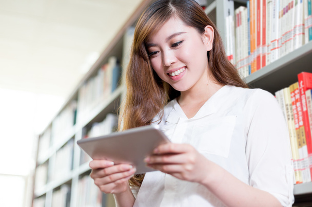 Asiatique femme étudiant à l'aide tablette dans la bibliothèque
 - Photo, image