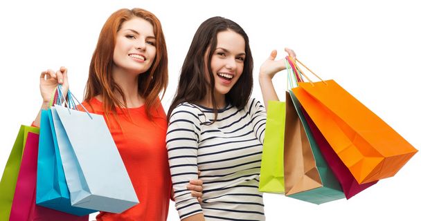 two smiling teenage girls with shopping bags - Valokuva, kuva