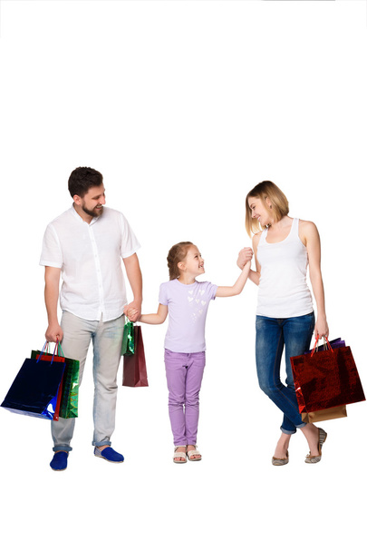 Happy family with shopping bags standing at studio  - 写真・画像