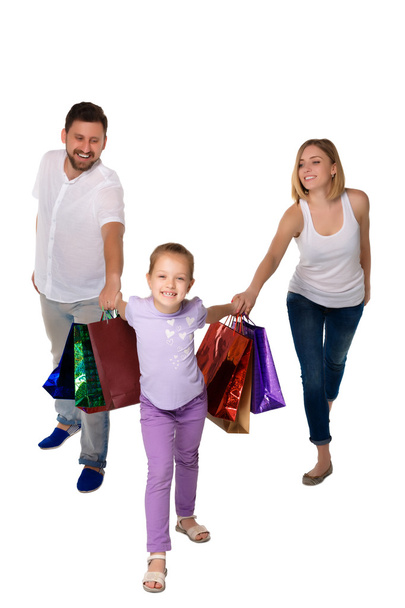 Happy family with shopping bags standing at studio  - Фото, изображение