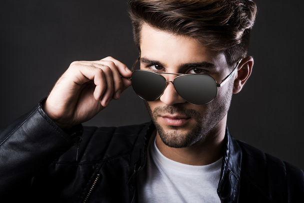 Handsome man adjusting his sunglasses - Foto, imagen