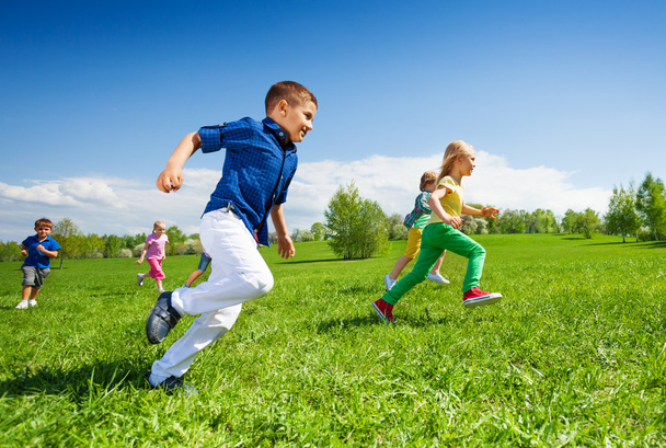 Happy running kids in green park - Фото, изображение