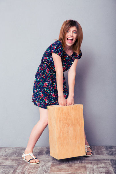 Funny young woman holding wooden box - Фото, изображение