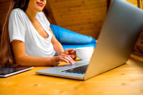 Femme travaillant avec un ordinateur portable sur le sol en bois
 - Photo, image
